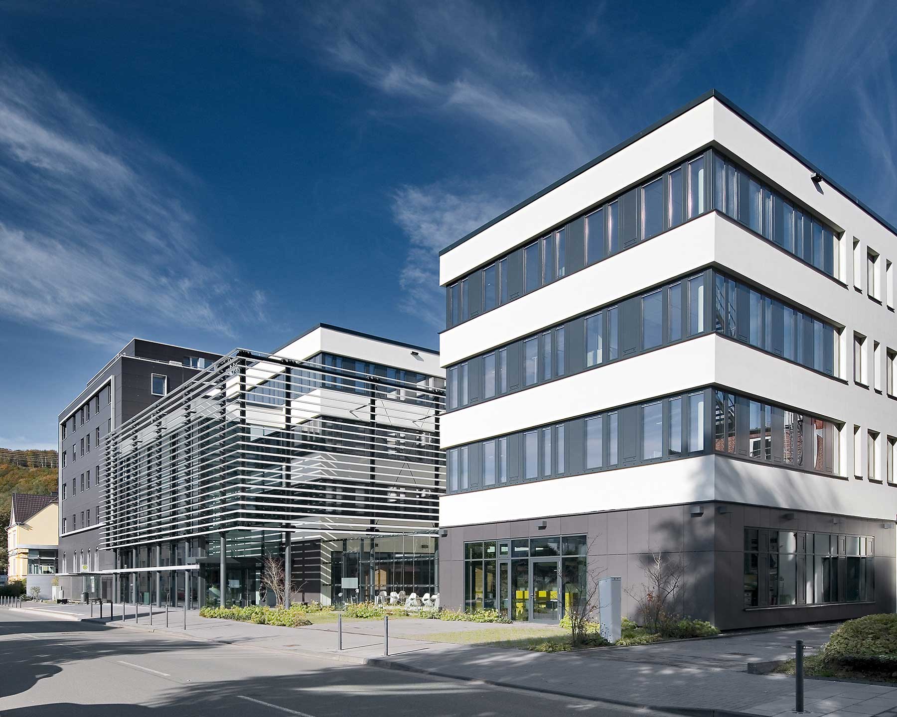 Außenfassade Eingangsbereich mit Lamellenverkleidung und Nebengebäude