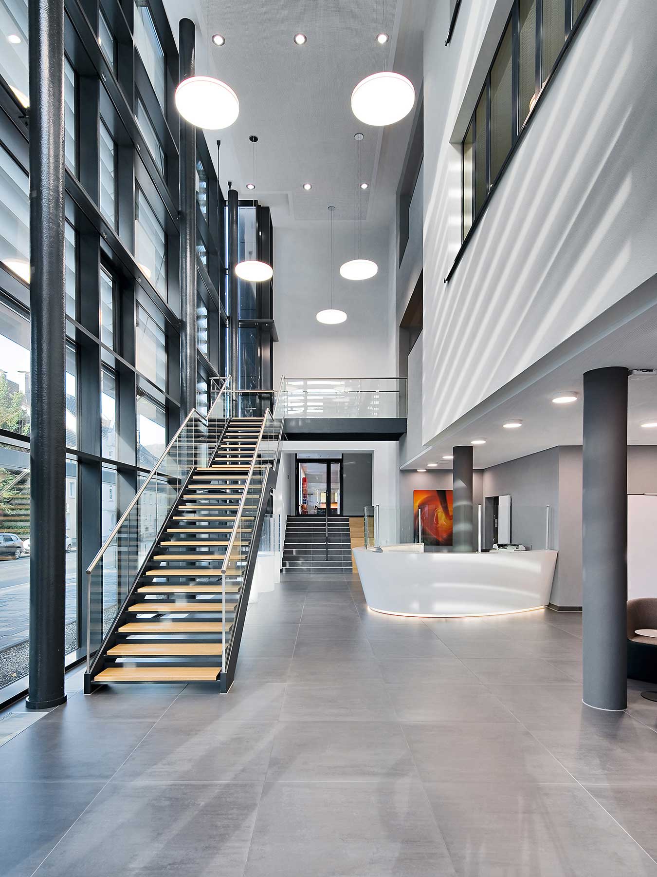 Foyer, Empfangsbereich und freistehende Stahltreppe ins Obergeschoss