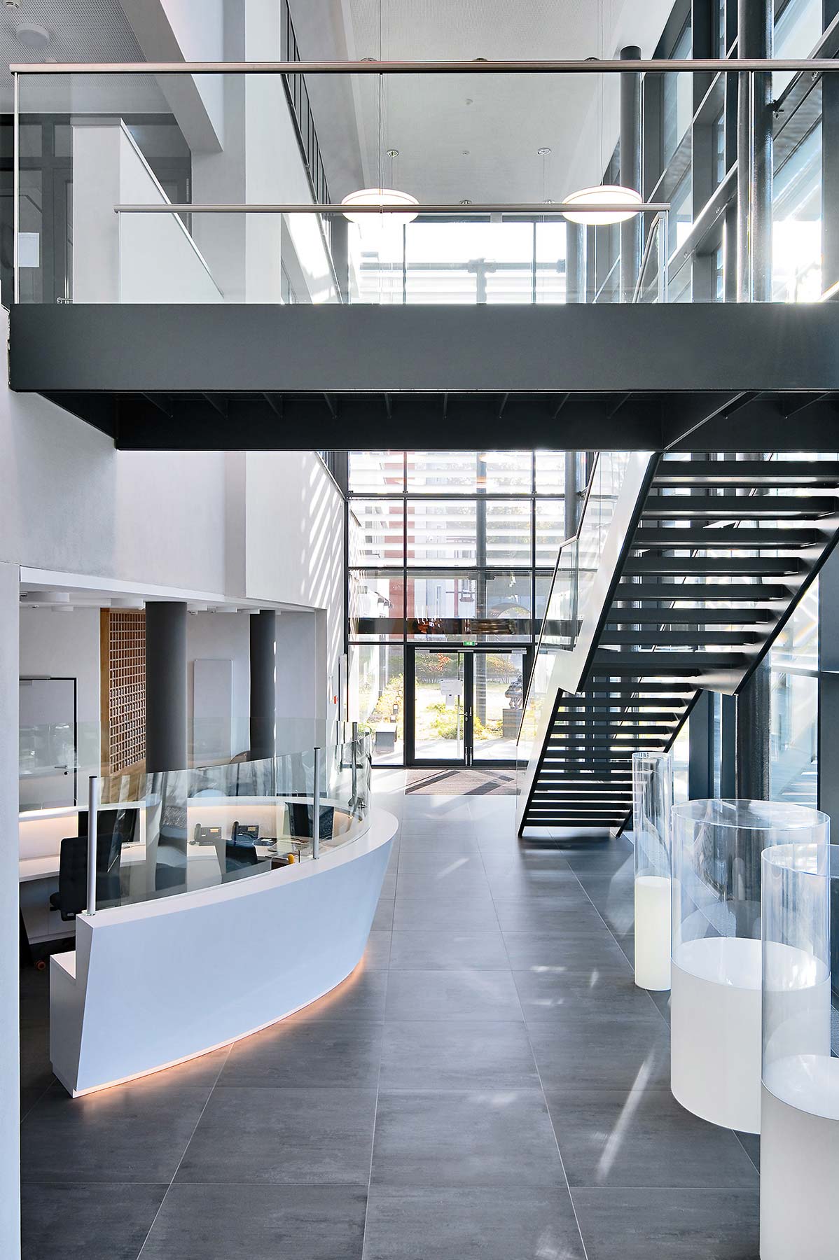Foyer, Empfangsbereich und freistehende Stahltreppe ins Obergeschoss